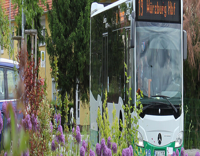 Bus des ÖPNV an einem Blumenbeet